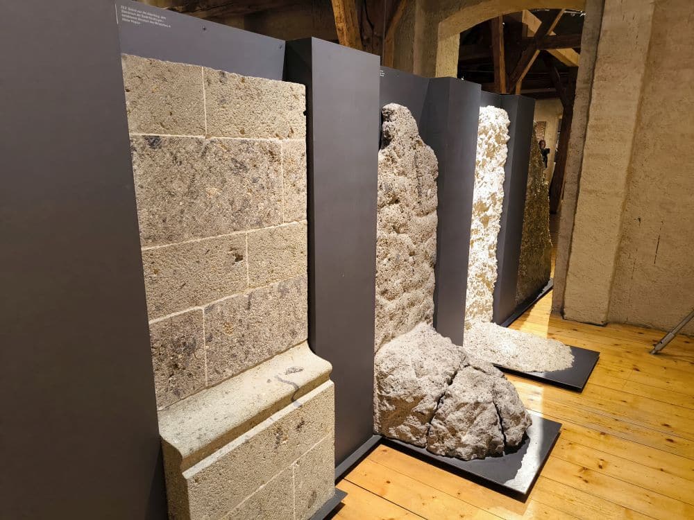 Im Rieskratermuseum in Nördlingen sind vier vertikale Steinmauerabschnitte unterschiedlicher Textur und Farbe auf dunklen Tafeln aufrecht stehend ausgestellt. Die Steine, die an die Schwäbische Alb erinnern, wirken vor dem Hintergrund von Holzböden und Balken verwittert und uralt.